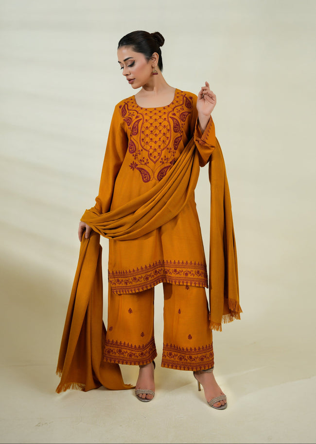 Woman wearing a mustard yellow traditional outfit with embroidery on a beige background Hover Image